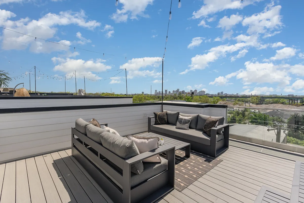 A stylish rooftop deck with a comfortable outdoor seating area, string lights overhead, and a captivating view of Nashville’s city skyline. The space feels inviting for both relaxing and celebrating, especially as dusk falls and the city lights up.